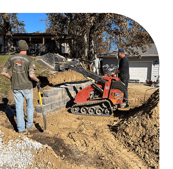 A man is using a small machine to cut the wall.