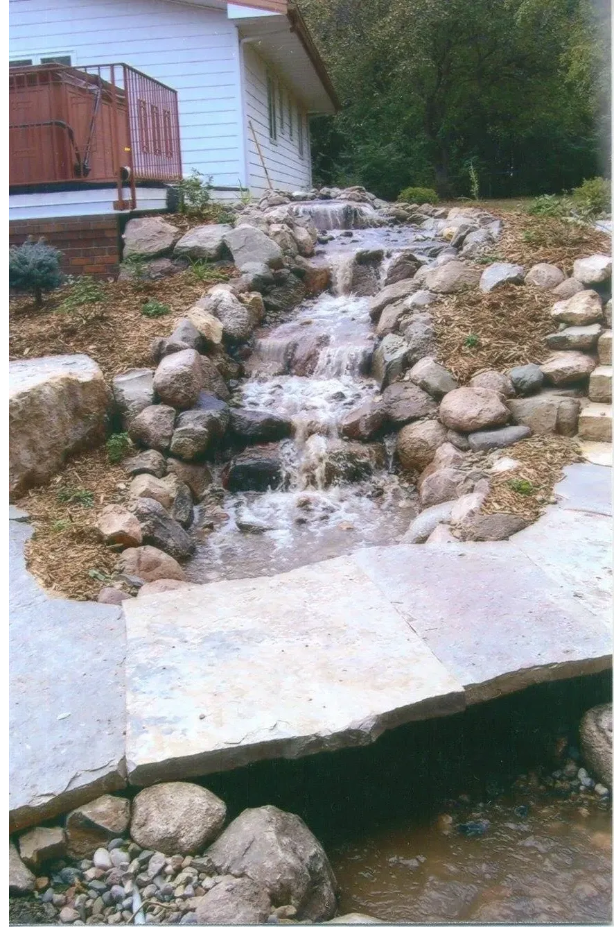 A small waterfall in the middle of a garden.