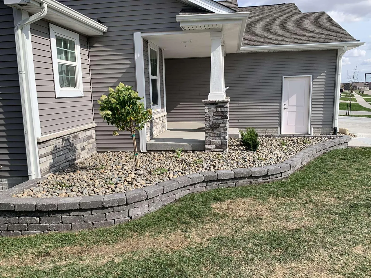 A house with a stone wall and landscaping.