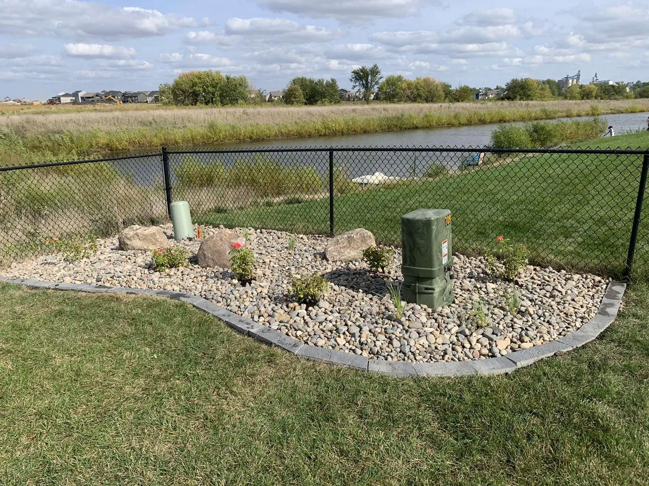 A grassy area with rocks and water.