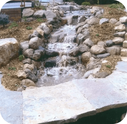 A small waterfall in the middle of a garden.