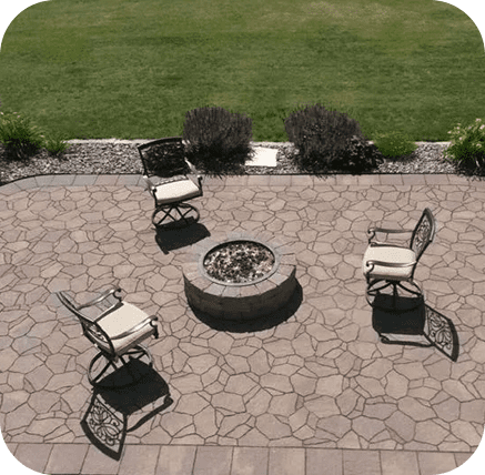 A patio with chairs and fire pit in the middle of it.