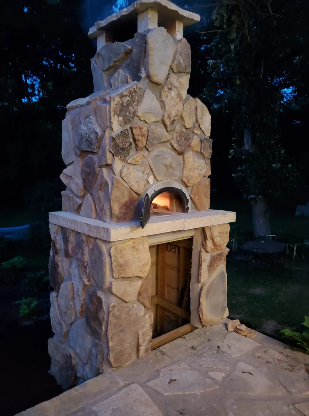 A stone fireplace with an oven built into it.