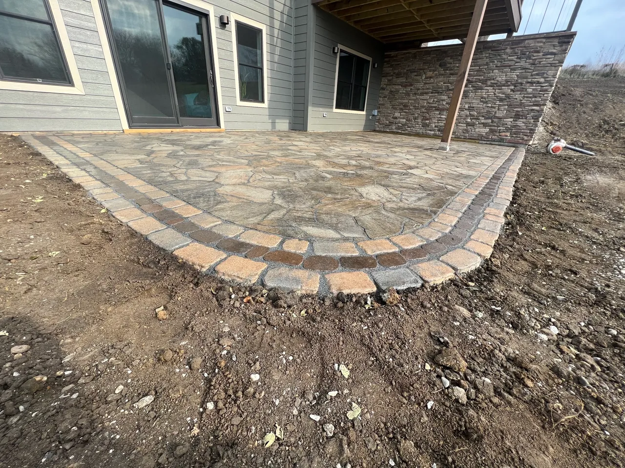 A patio with brick and stone in the middle of it.