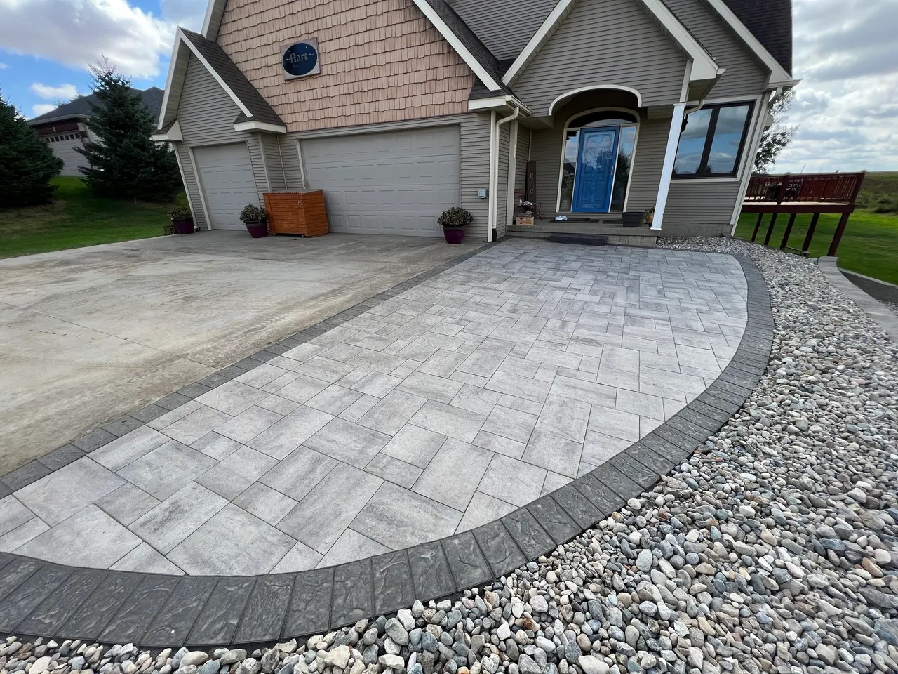 A driveway with a stone walkway and gravel.