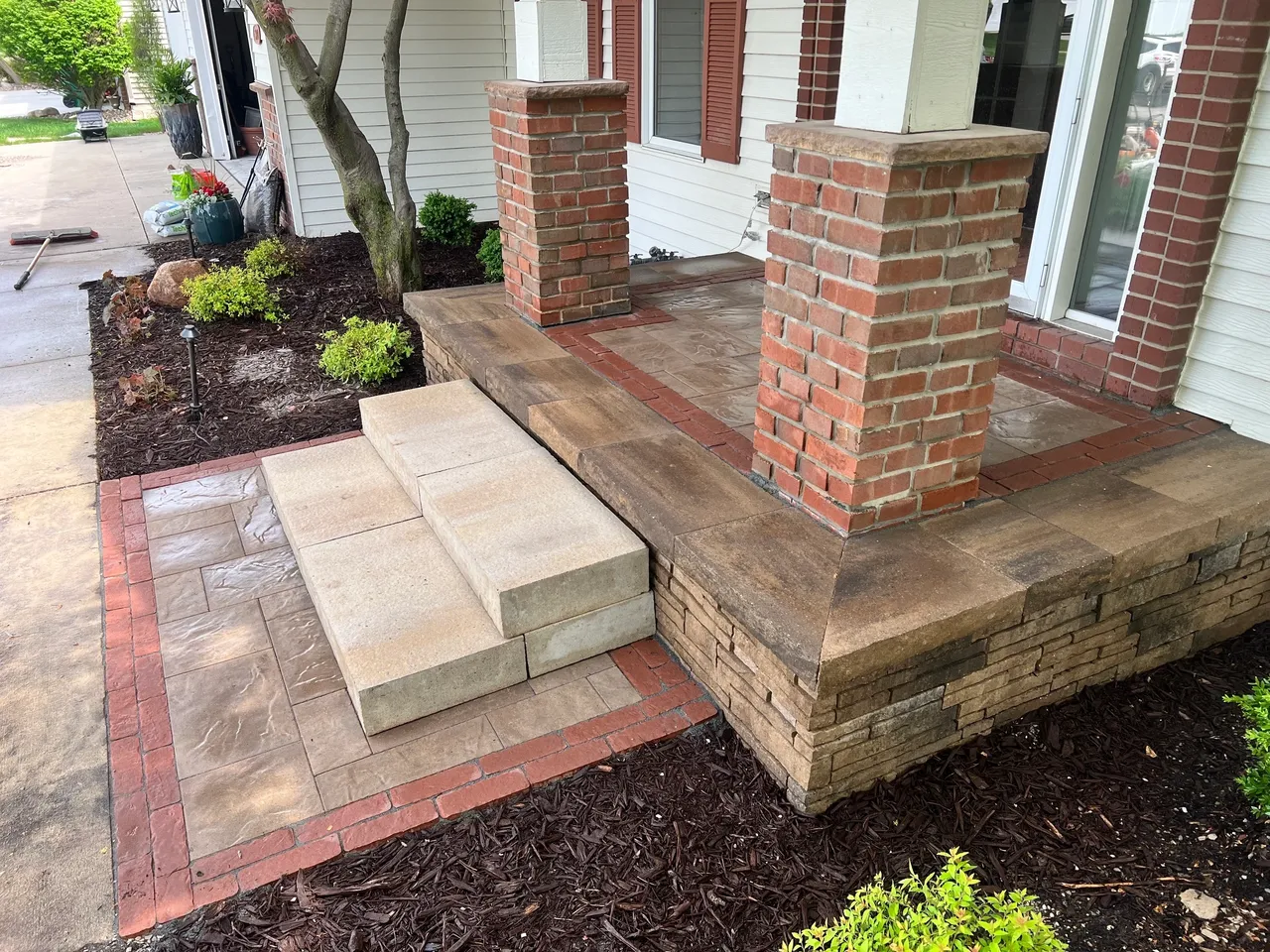 A brick walkway with steps leading to the front door.