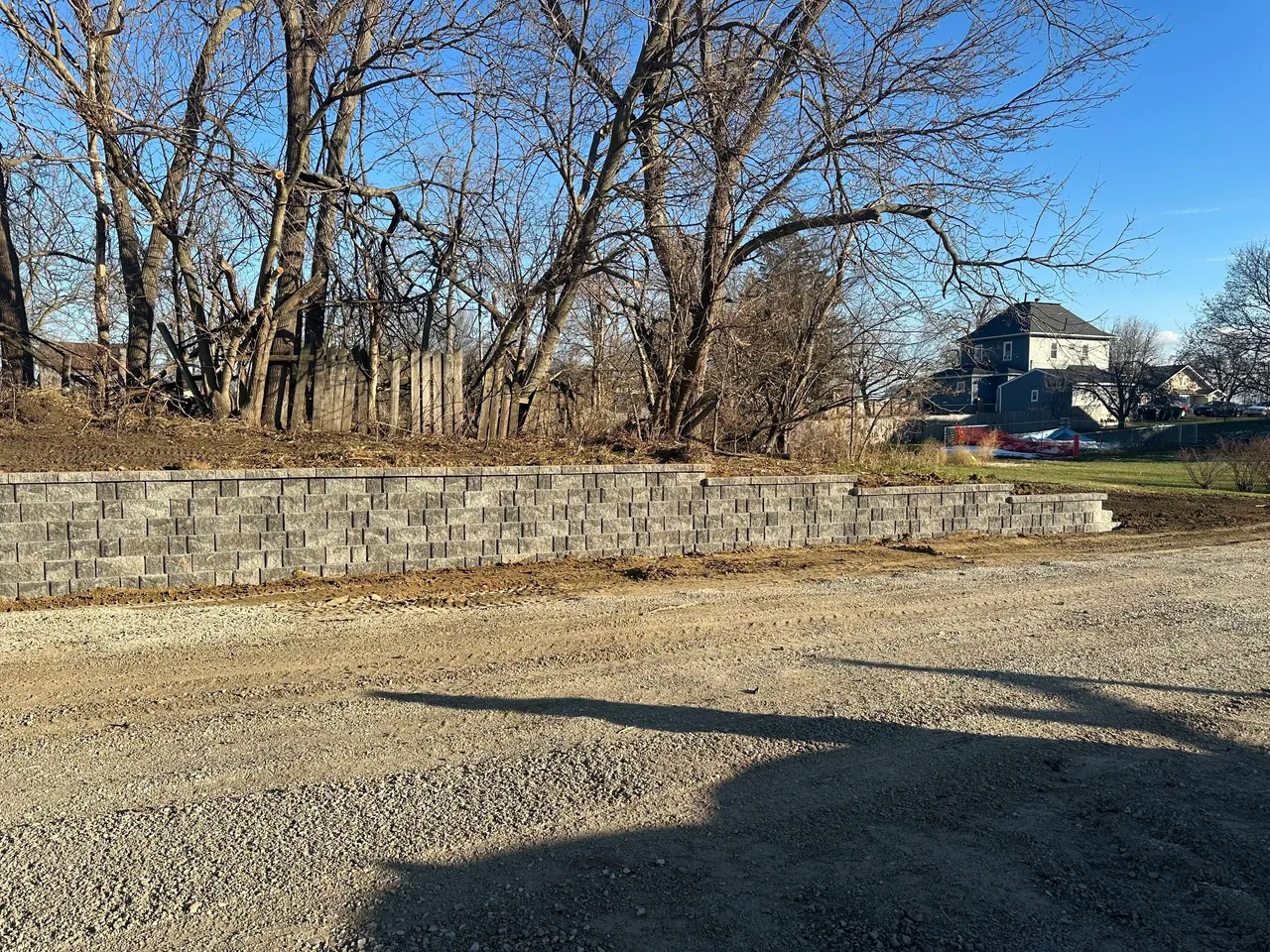 A large stone wall in front of trees.