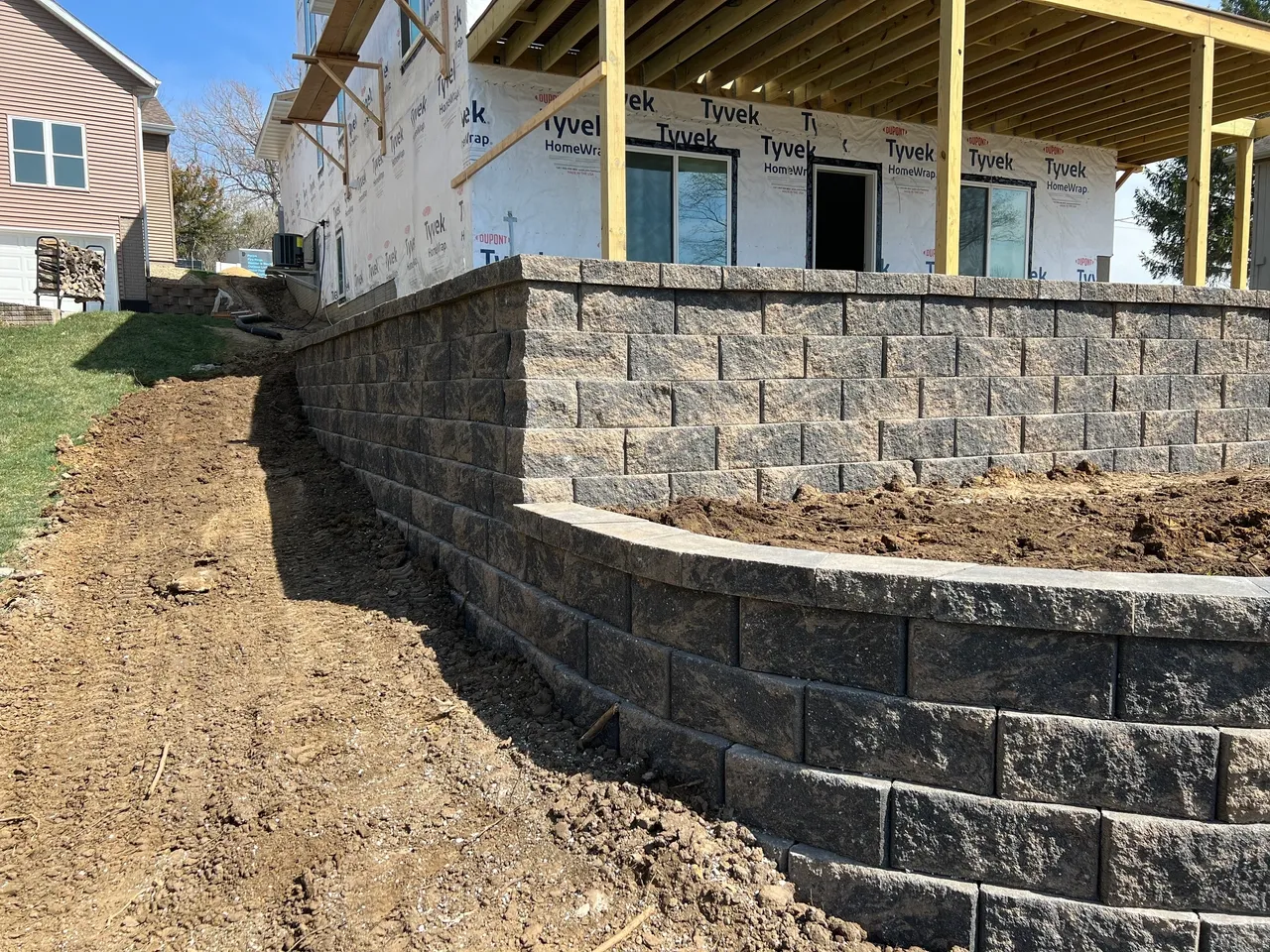 A building under construction with a stone wall.