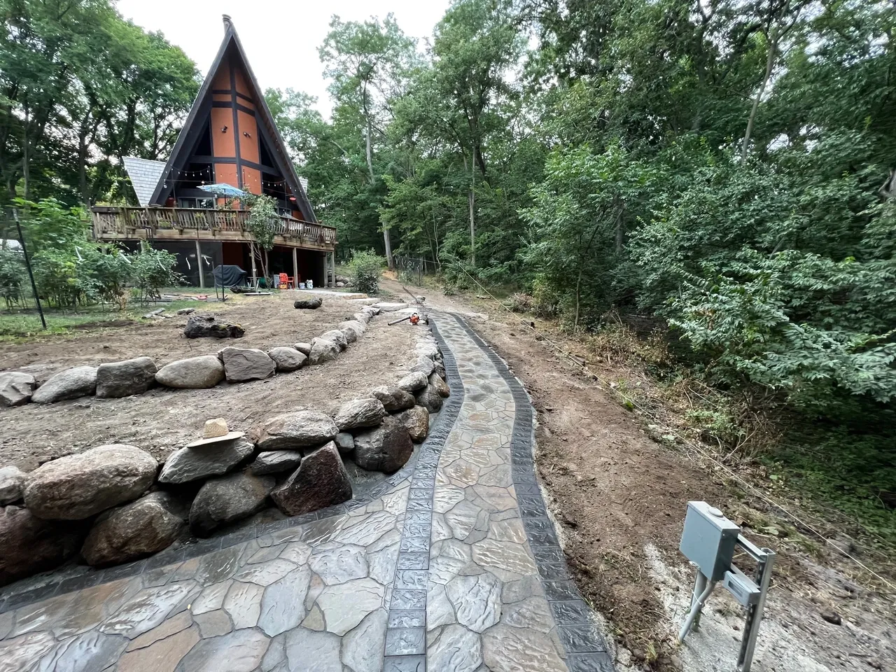 A stone path leading to a house in the woods.