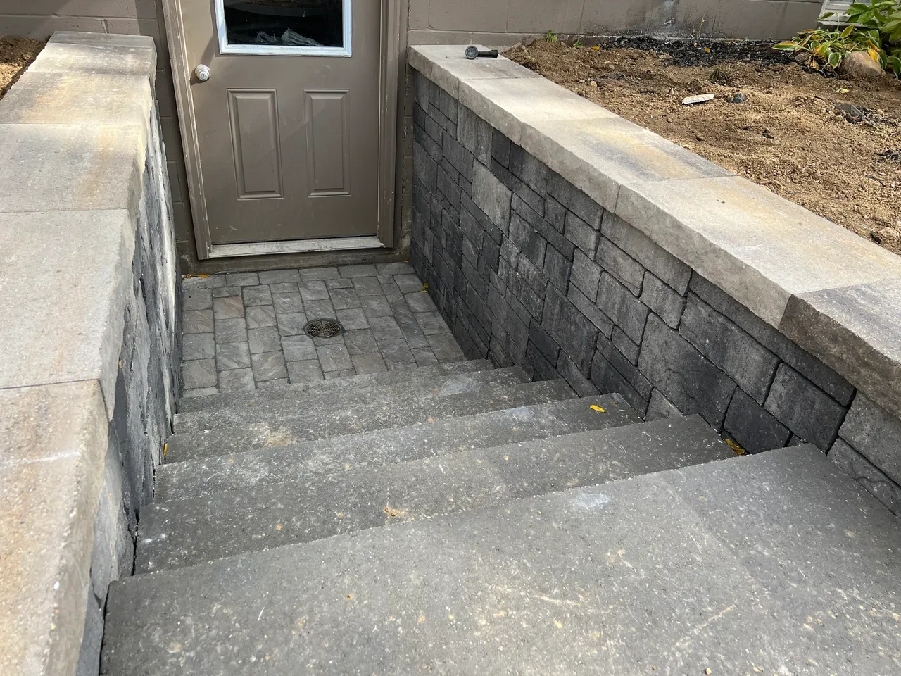 A cement block wall with steps leading to the front door.