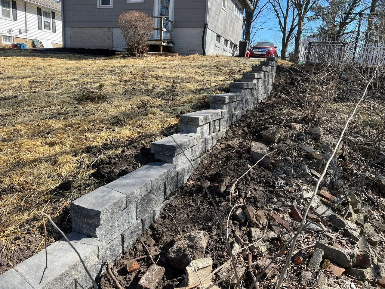 A brick wall in the middle of a yard.