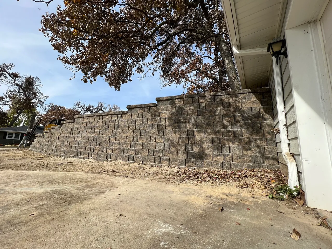 A large concrete block wall with trees in the background.