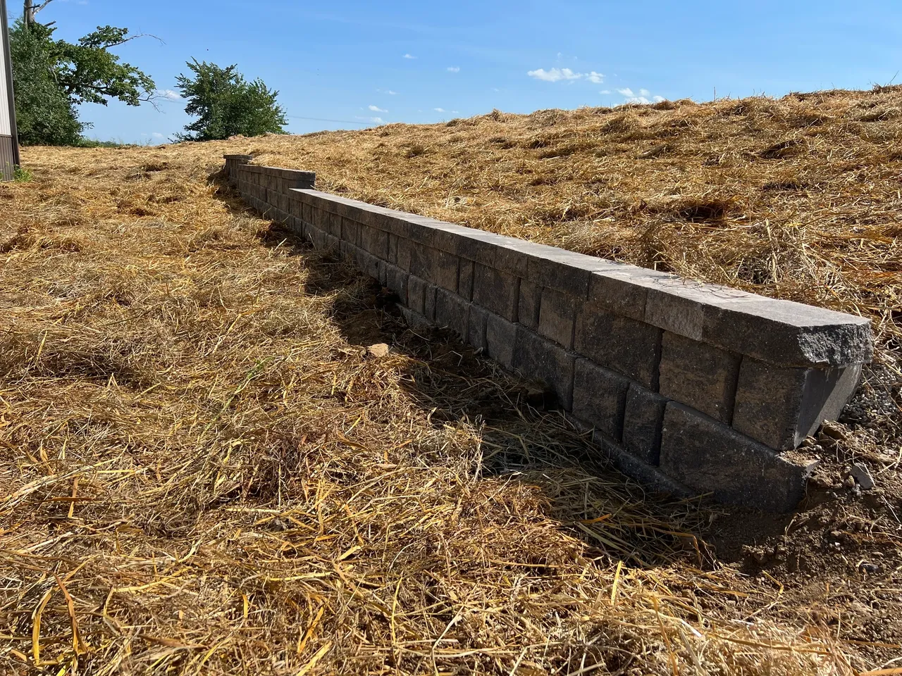 A brick wall in the middle of a field.