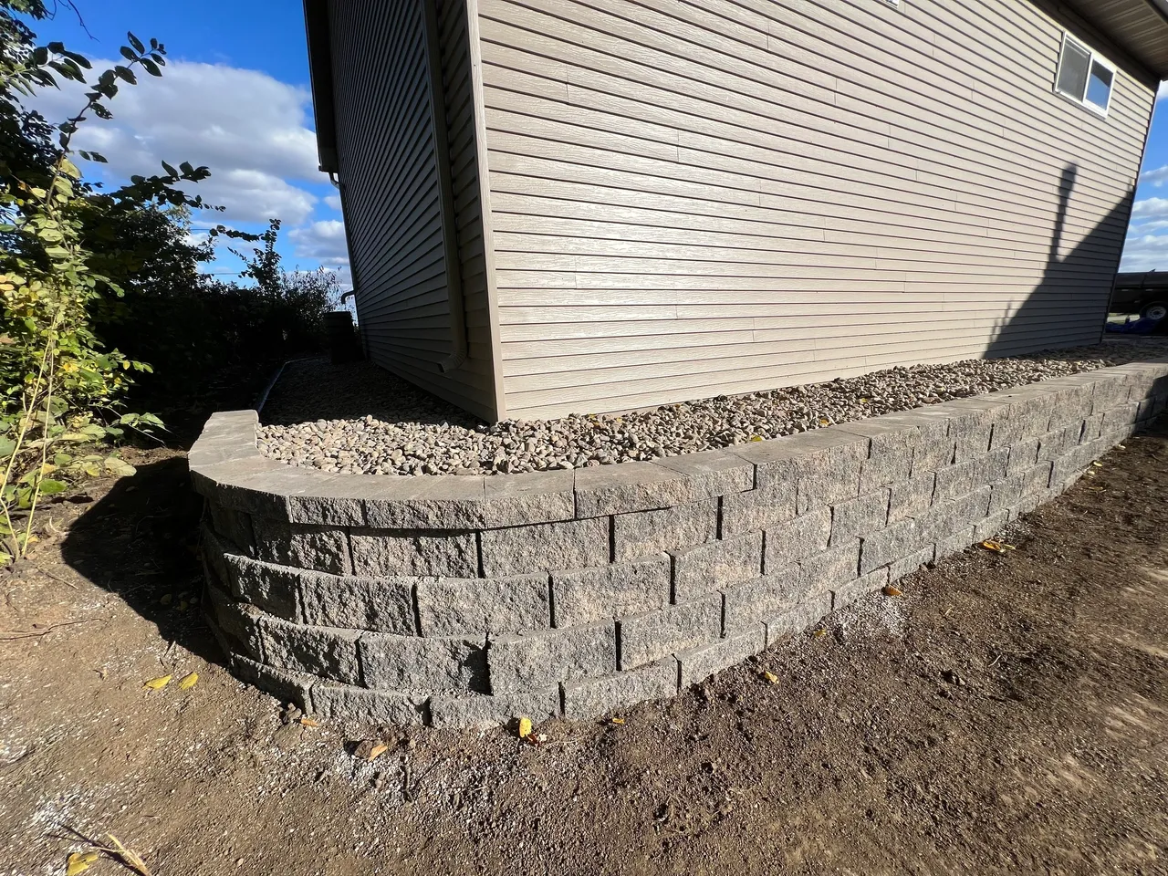 A brick wall with a concrete base around it