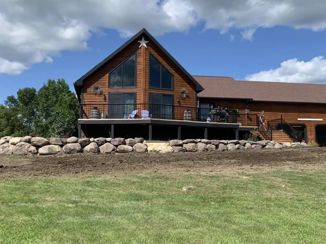 A large house with horses in the yard.