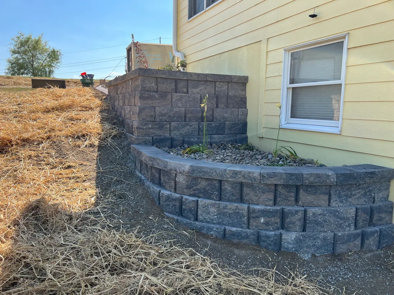 A house with a wall and planter in it