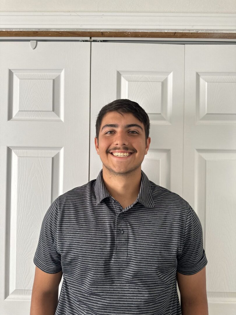 A man standing in front of two white doors.